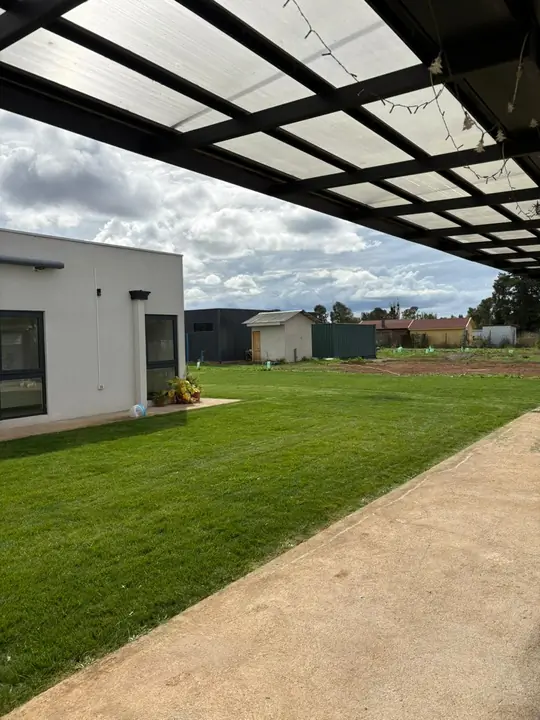 Casa moderna con césped nuevo y cielo despejado